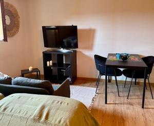 a living room with a table and a tv at Chambre double 7km from track in Stoumont