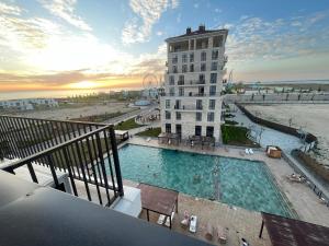 a building with a swimming pool in front of a building at Апартаменты Aktau Rivera in Aktau