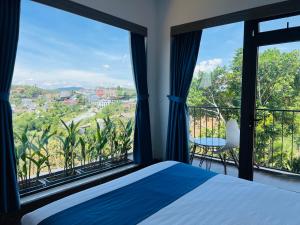a bedroom with a bed and large windows at Nắng's Villa & Coffee in Ấp Ða Lợi