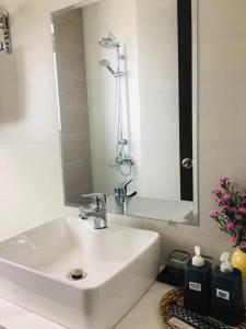 a white bathroom with a sink and a shower at Nắng's Villa & Coffee in Ấp Ða Lợi