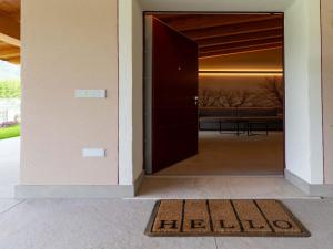a door leading into a house with a welcome mat at Idyllic cottage next to the beautiful Lake Idro in Crone +106 photos