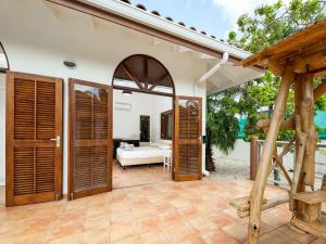 een open patio met houten deuren en een woonkamer bij Holiday villa at Jan Thielstrand in Willemstad in Jan Thiel +15 foto's