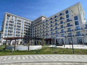 a large apartment building with a playground in front of it at Апартаменты Aktau Rivera in Aktau
