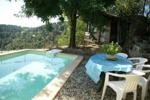a table and chairs next to a swimming pool at Detached holiday home in Chassiers with pool in Chassiers +23 photos