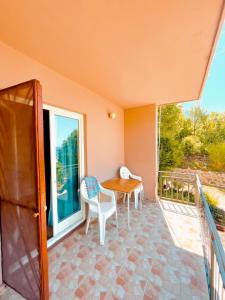 a porch with a table and chairs on a balcony at Panorama in Čanj +9 photos