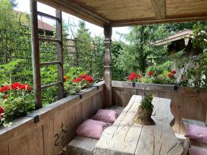 a porch with pillows and a wooden table with flowers at Eco-friendly chalet near the lake in Asten in Tittmoning