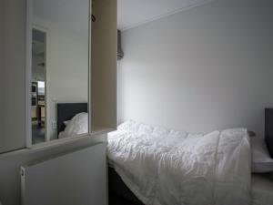 a white bed in a room with a mirror at Lovely Holiday Home in Kattendijke near Centre in Kattendijke