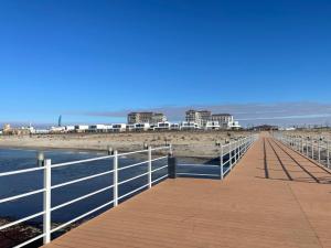 a boardwalk on the beach with buildings in the background at Апартаменты Aktau Rivera in Aktau +9 photos