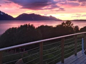 een zonsondergang boven een waterlichaam met bergen bij 6 person holiday home in Olderdalen in Olderdalen