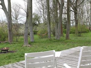 two white chairs sitting on a wooden walkway in a park at Gorgeous apartment in Neuburg with terrace in Neuburg-Steinhausen +91 photos