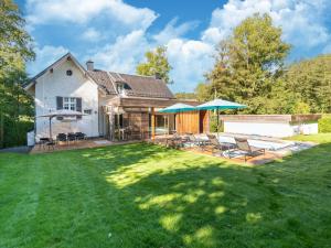 a house with a yard with chairs and a patio at Holiday Home in Spa near Thermal Baths in Spa +66 photos