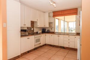 Una cocina con gabinetes blancos y una ventana. en Rondevoux 16, en Margate