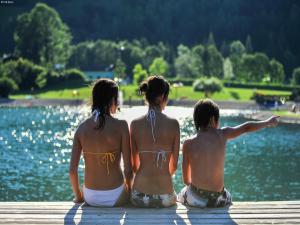 three girls sitting on a dock looking at a lake at Sprawling Mansion near Ski Area in Salzburg in Eben im Pongau +55 photos