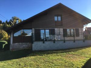 a house with a large porch and balcony at Elegant Chalet in Gerbépal in cosy environment in Gerbépal