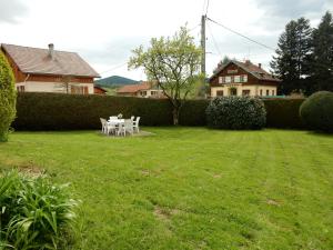 a table and chairs in the yard of a house at Elegant Chalet in Gerbépal in cosy environment in Gerbépal