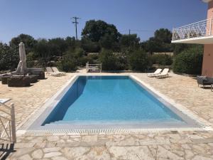 a swimming pool in a yard with chairs and a house at Luxurious Villa in Peloponnese with Swimming Pool in Kamária +89 photos