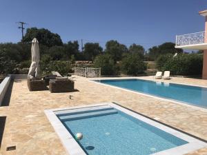 a swimming pool in a yard next to a house at Luxurious Villa in Peloponnese with Swimming Pool in Kamária