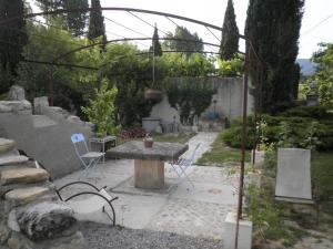 a patio with a table and chairs in a garden at Charming Cottage in Oppède amidst Vineyards in Maubec