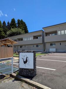 a sign in a parking lot in front of a building at 南阿蘇サウナ5gaku G5 in Minami Aso +6 photos