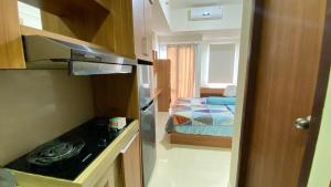 PampangにあるApartemen VidaView Unit 33i By Millproのキッチン(コンロ付)、ベッドルーム(ベッド1台付)