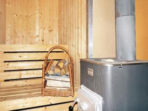 a wooden room with a bird cage next to a refrigerator at 4 person holiday home in Vetlanda in Lillarp