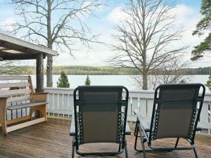 two chairs on a deck with a view of a lake at 4 person holiday home in Vetlanda in Lillarp