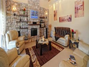 un soggiorno con divani e un muro in pietra di Scenic Villa in Paleokastrites with Sauna a Gouviá