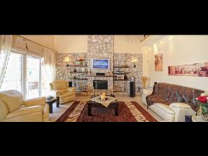 un soggiorno con divano e camino di Scenic Villa in Paleokastrites with Sauna a Gouviá