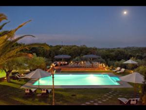una grande piscina con ombrelloni in un cortile di Scenic Villa in Paleokastrites with Sauna a Gouviá