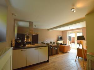 a kitchen with white cabinets and a living room at Stunning Holiday Home near Forest in Slenaken in Slenaken