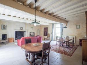 a living room with a table and a red couch at Holiday Home in Saint-Laurent-de-la-Salle with Pool in La Chapelle-Thémer