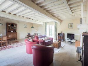 a living room with red furniture and a fireplace at Holiday Home in Saint-Laurent-de-la-Salle with Pool in La Chapelle-Thémer
