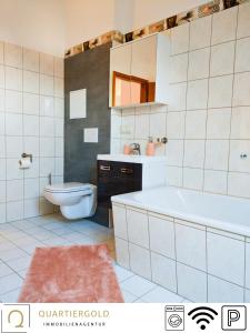 a bathroom with a tub and a toilet and a sink at Monteurwohnung mit Stil in Schwarzheide