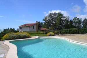 a swimming pool in front of a house at Agriturismo il Roccolo in Pantasina
