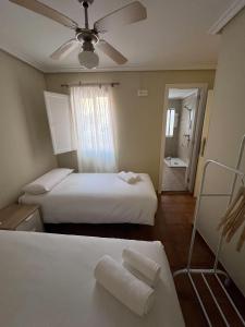 a bedroom with two beds and a ceiling fan at Hostal Entre Puertas in Aranda de Duero