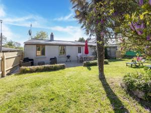 ein weißes Haus mit einem Garten mit einem Baum in der Unterkunft Charming Home with Orchard in Tamerville