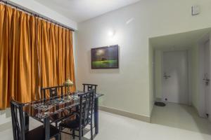a dining room with an orange curtain and a table at Tusti Homestay in Guwahati