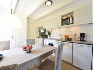 una cocina con una mesa de madera y un bol de fruta en Cozy Holiday Home in Zonnemaire near lakebeach, en Zonnemaire
