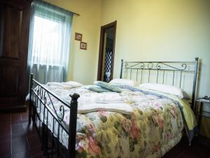 a bedroom with a bed with a blanket and a window at Holiday Home in Paciano with Swimming Pool,Terrace,Billiards in Paciano