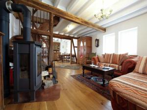 Una sala de estar con chimenea y un sofá. en Nostalgic apartment in the Eifel region, en Schleiden
