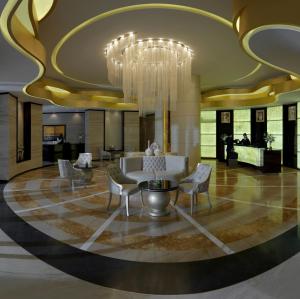 um átrio com um candelabro e um sofá e cadeiras em DAMAC Maison Cour Jardin no Dubai