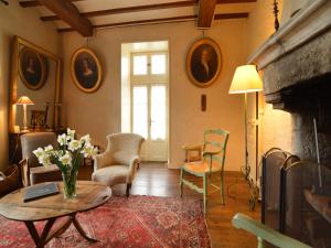 a living room with a fireplace and a table and chairs at Saint-Paul Pool Retreat in Saint-Paul-du-Bois