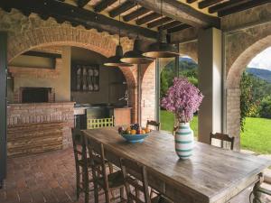 a kitchen with a wooden table with a vase of flowers at Ritzy Villa on a Wine Estate in Arezzo with Pool in Arezzo