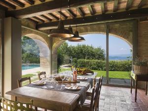 a dining room with a table and a view of a pool at Ritzy Villa on a Wine Estate in Arezzo with Pool in Arezzo