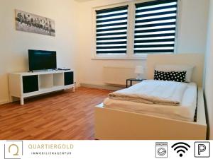 een slaapkamer met een bed en een televisie. bij Apartment I Business I Monteure in Lauchhammer