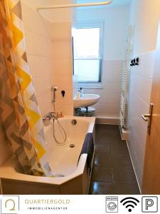 een badkamer met een bad en een wastafel bij Apartment I Business I Monteure in Lauchhammer