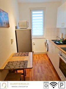 een keuken met een koelkast en een tafel. bij Apartment I Business I Monteure in Lauchhammer