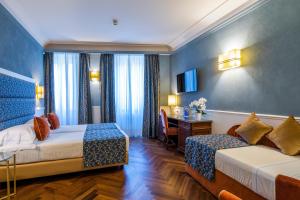 a hotel room with two beds and a desk at Rivoli Boutique Hotel in Florence +80 photos