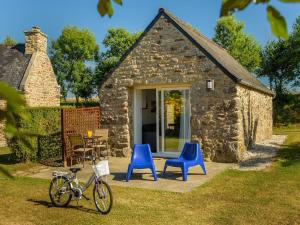 PlouguinにあるPeaceful Holiday Home in Plouguin with Indoor Poolの青い椅子と自転車のある小さな石造りの家