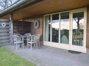 a patio with a table and chairs on a house at Holiday Home in Geesteren with Roof Terrace,Garden Furniture in Geesteren